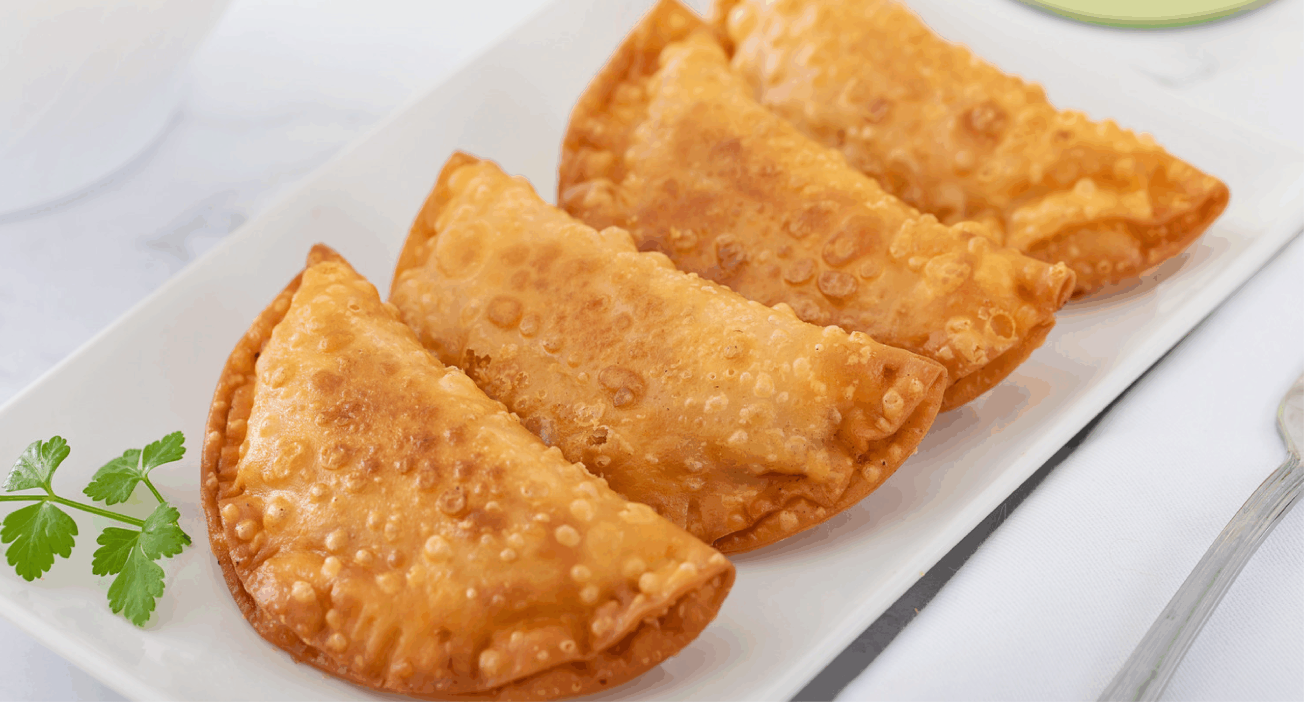 Empanadillas fritas doradas servidas en un plato.